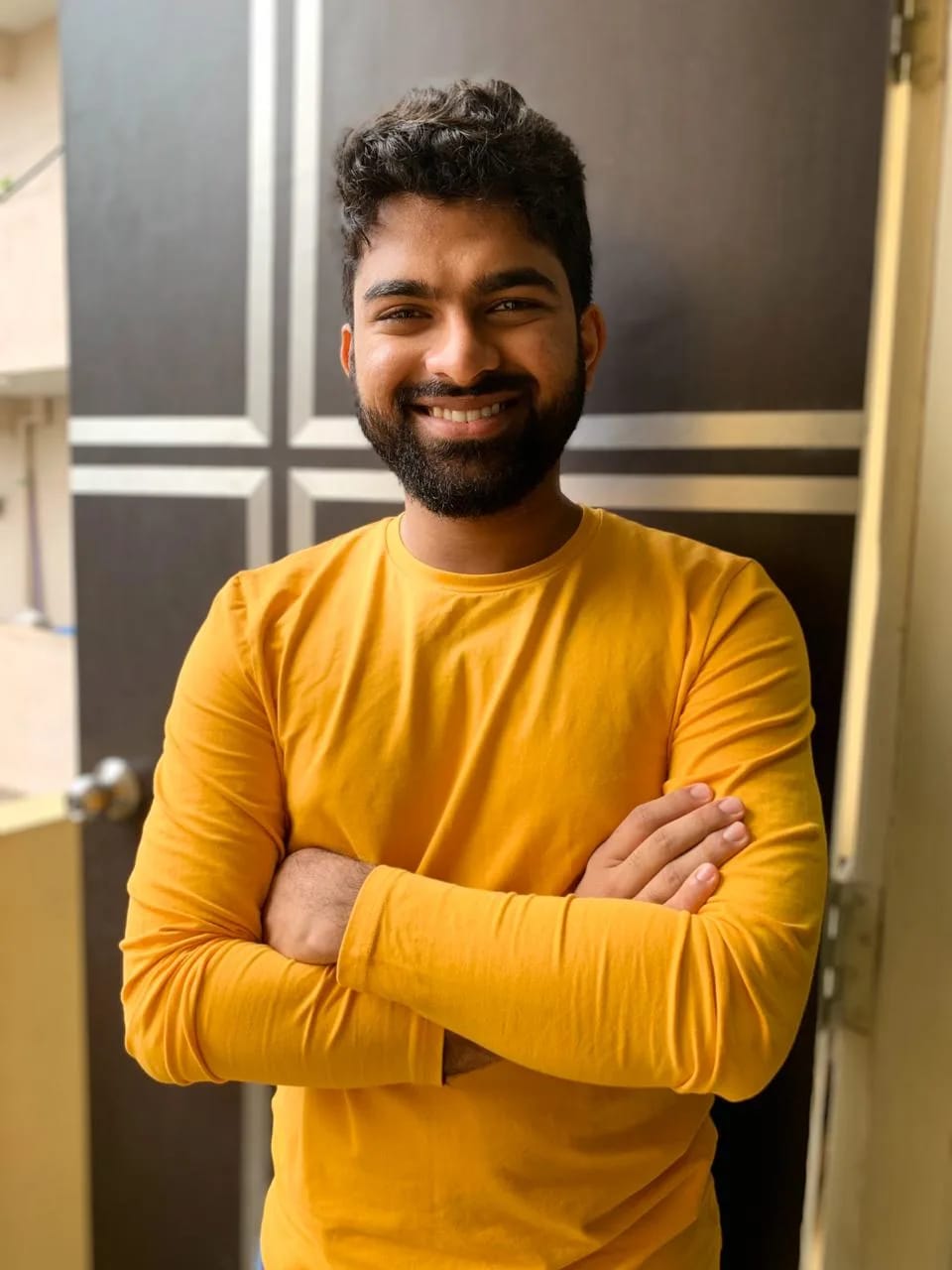 Man wearing a yellow t-shirt facing the camera