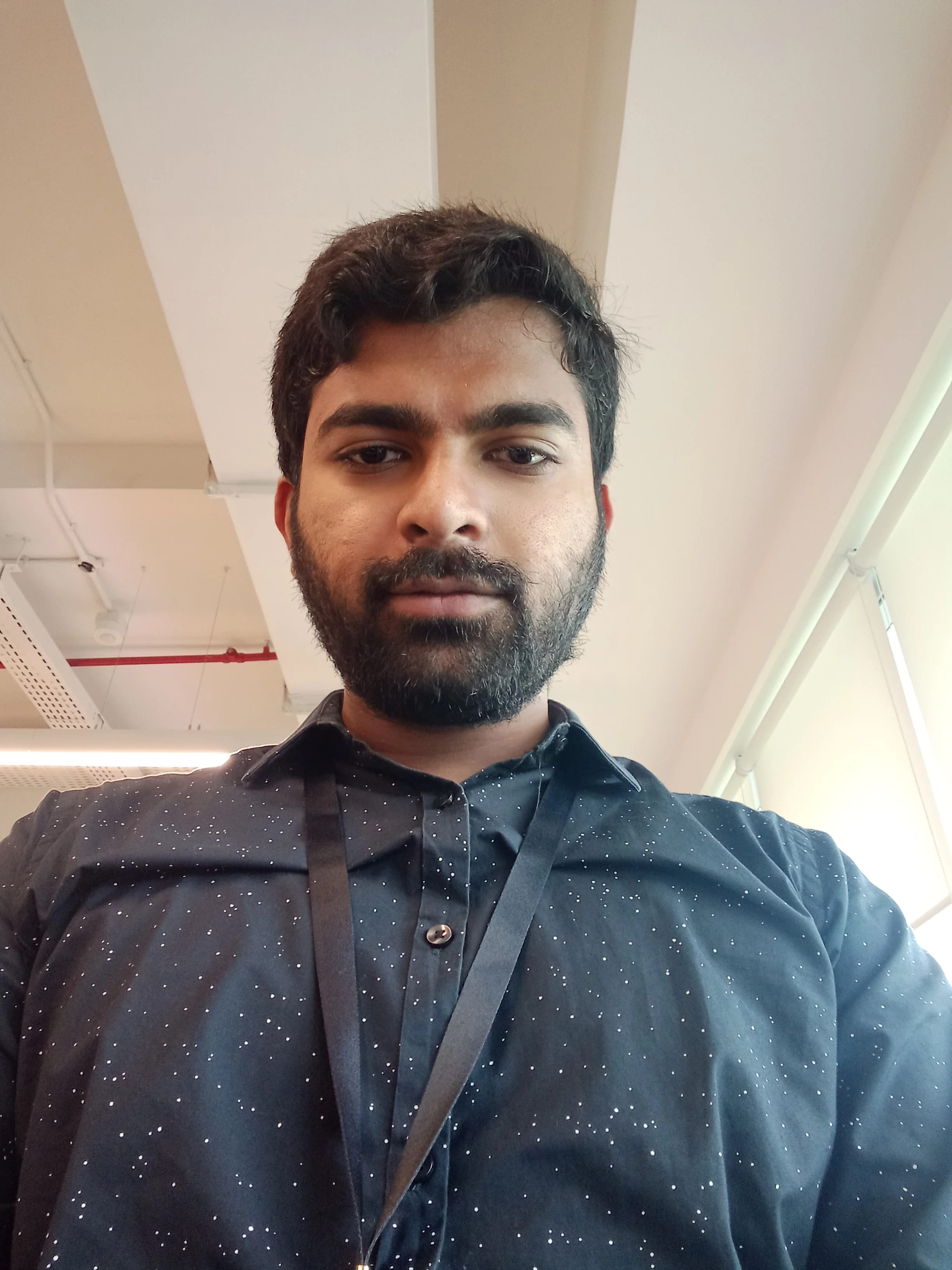 Selfie of a man wearing a black shirt and an ID card